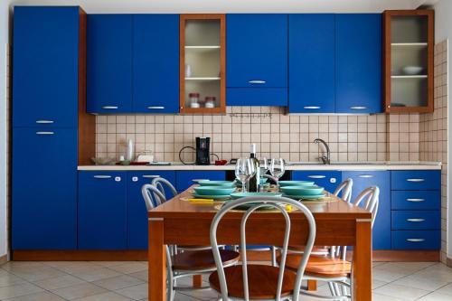a kitchen with blue cabinets and a table with chairs at casa azul netflix near the sea in Scoglitti