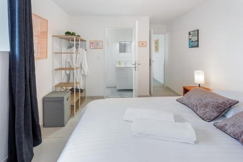 une chambre avec un lit blanc et une salle de bain dans l'établissement O terminus - T2 rénové - 5 min Gare et Jardin des plantes - Hyper Clame, à Nantes