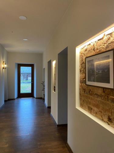 a hallway with a stone wall and a painting on the wall at Laumės dvaras in Kruopinė