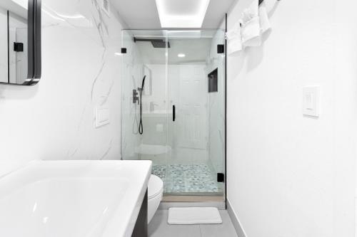 une salle de bain blanche avec douche et toilettes dans l'établissement Hard Rock Villa Pool, Game Room & Beach Fun, à Miami Gardens