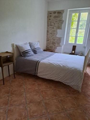 un grand lit dans une chambre avec une fenêtre dans l'établissement Large nature lodge, à Montazeau