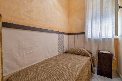 a small bedroom with a bed and a window at Casa Loretta 2 in Valledoria