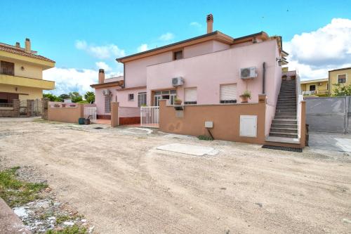 a pink house on a dirt road at Casa Loretta 2 in Valledoria