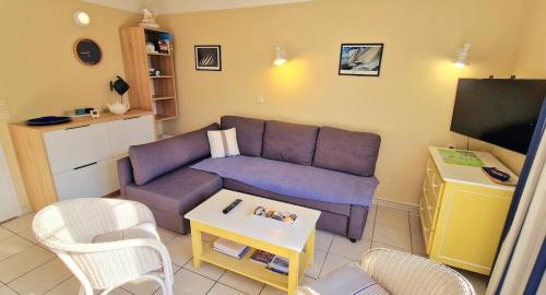 un salon avec un canapé violet et une télévision dans l'établissement 