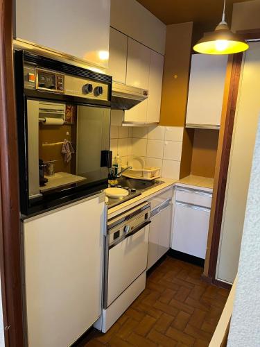 a kitchen with white cabinets and a stove top oven at Mont Blanc Panorama in Chamonix-Mont-Blanc