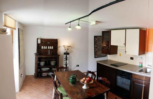 a kitchen and dining room with a table with a bowl of fruit at Wild Valley Rustico Romantico, Intragna, Centovalli in Intragna