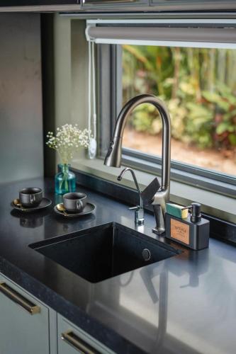 a kitchen counter with a sink and two cups at SO Sky Sea View Villa in Salad Beach