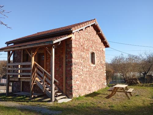 a small brick building with a bench next to it at Le poulailler in Plancher-Bas