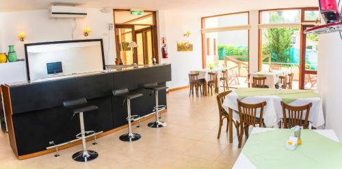 a restaurant with a bar with tables and chairs at Panacea Hotel in Villa General Belgrano