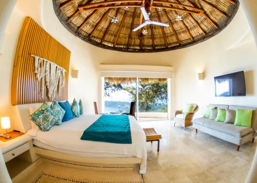 Un dormitorio con una cama grande y una ventana grande en Casa Wapa Espectacular Villa Boho Chic en Acapulco, en Acapulco