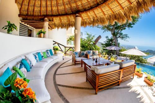 a patio with a table and chairs and a pool at Casa Wapa Espectacular Villa Boho Chic en Acapulco in Acapulco