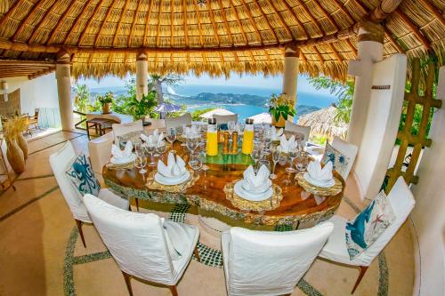 a dining room with a table and chairs and the ocean at Casa Wapa Espectacular Villa Boho Chic en Acapulco in Acapulco