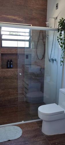 a bathroom with a glass shower with a toilet at Chalé de alto padrão em condomínio in Santa Rita do Sapucaí