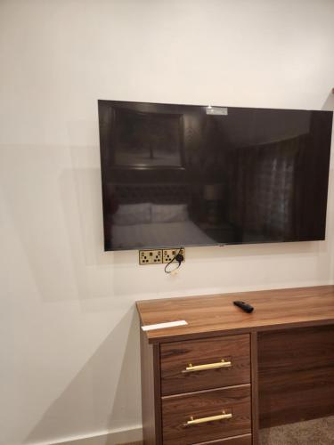 a flat screen tv on a wall in a room at CITY CENTRE LUXURY House WITH THREE VERY LARGE SIZE BEDROOMS in Belfast