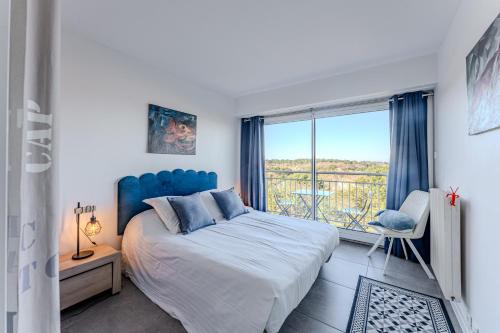une chambre avec un grand lit et une grande fenêtre dans l'établissement Appartement vue bassin, à Arcachon