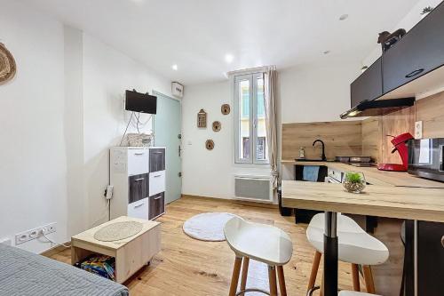 une cuisine avec une table et des chaises dans une pièce dans l'établissement Charming studio near the city center of Narbonne, à Narbonne