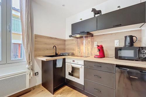 une cuisine avec des appareils en acier inoxydable et un micro-ondes dans l'établissement Charming studio near the city center of Narbonne, à Narbonne