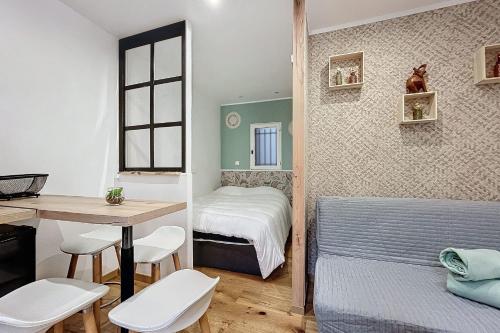 - une petite chambre avec un lit, une table et des chaises dans l'établissement Charming studio near the city center of Narbonne, à Narbonne