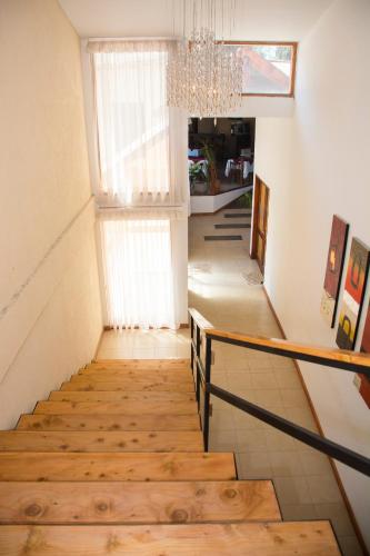 a staircase in a house with a chandelier at Panacea Hotel in Villa General Belgrano