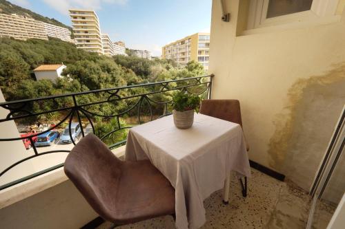une table et des chaises sur un balcon avec une plante dans l'établissement Valentina - Sea view Luminous Calm - by TGB, à Ajaccio