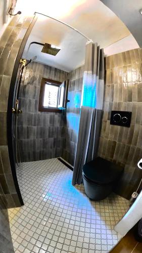 a bathroom with a shower with a black toilet at Casa nel centro storico in San Gimignano