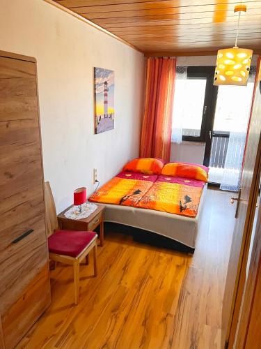 a bedroom with a bed and a chair in it at Frühstückspension See-Panorama in Podersdorf am See