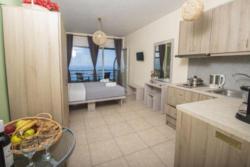 a kitchen with a view of a room with a bed at Fantastico Studios in Kalamitsi
