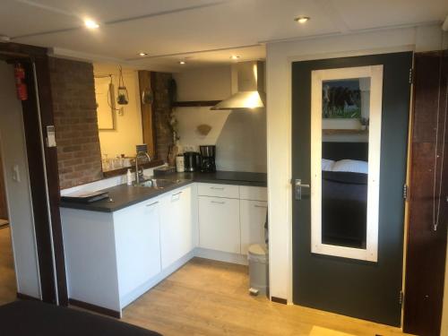 a small kitchen with white cabinets and a sink at B&B CaSandra in Volendam