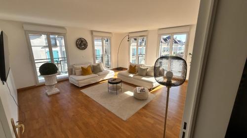 a living room with white furniture and large windows at Somptueux Appart' Aux Portes de Disneyland in Serris