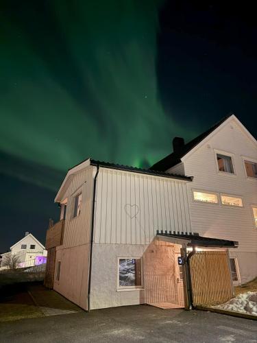una casa con el cielo verde en el fondo en Arctic Retreat - two separate bedroom apartment, en Tromsø