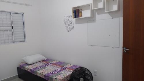 a room with a small bed in a white wall at House grey proximo Holambra UNASP in Artur Nogueira