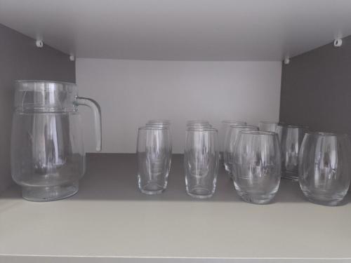 a row of clear glasses sitting on a shelf at House grey proximo Holambra UNASP in Artur Nogueira