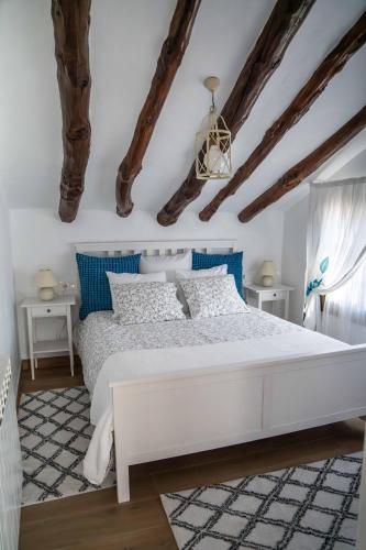 a bedroom with a white bed and blue accents at Cortijo Los Santeros in Castril