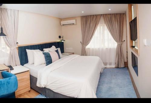 a bedroom with a large bed and a blue carpet at C. Apartments Annex in Abuja