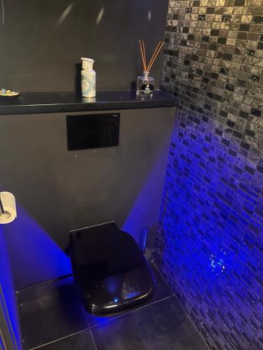 a bar with a black stool in a room with blue lights at Très beau duplex avec Jacuzzi privatif in Mandelieu-la-Napoule