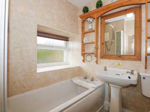 ein Badezimmer mit Waschbecken und Badewanne und Waschbecken in der Unterkunft Dalar Cottage in Brynkir