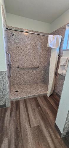a bathroom with a shower with a wooden floor at Travel Inn & Suite in Springerville