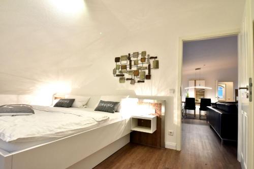 una camera con un grande letto bianco e un soggiorno di Ferienwohnung Strandnest in der Villa Gudrun Binz a Binz