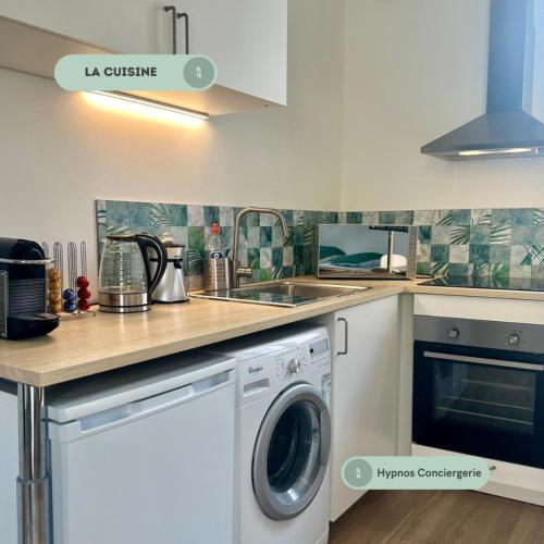 une cuisine avec une machine à laver et un évier dans l'établissement Le Bain de Compostelle, au Puy-en-Velay