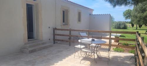 un patio avec une table et des chaises sur un balcon dans l'établissement Mas Sicard chambre d'hôtes en Camargue, à Arles