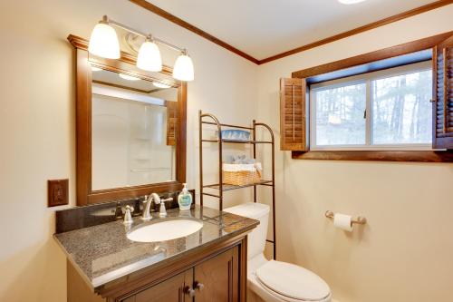 a bathroom with a sink and a toilet and a mirror at Hike and Ski Cabin with Fireplace in Franconia! in Franconia