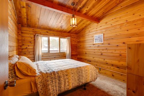 a bedroom with a bed in a log cabin at Hike and Ski Cabin with Fireplace in Franconia! in Franconia