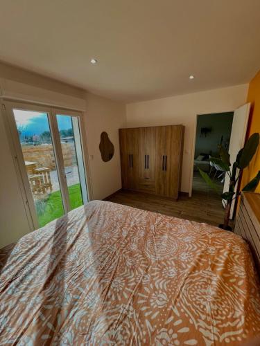 une chambre avec un grand lit et une grande fenêtre dans l'établissement Maison à l Ecurie, à Narbonne