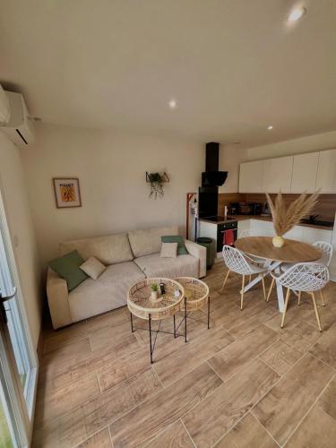 un salon avec un canapé, une table et des chaises dans l'établissement Maison à l Ecurie, à Narbonne