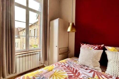 une chambre avec un lit et une grande fenêtre dans l'établissement Wilson 7, à Dijon