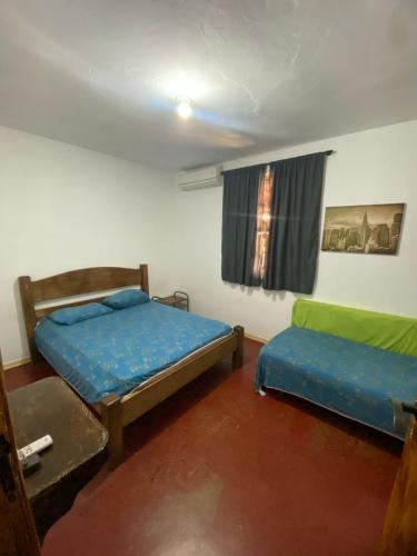 a room with two beds and a window at Chácara Samambaia Piracicaba in Piracicaba
