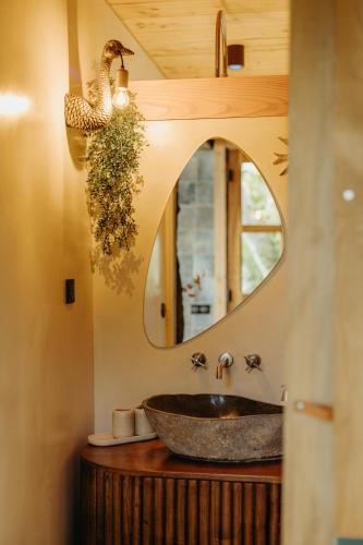 une salle de bain avec un lavabo et un miroir dans l'établissement Cabane La Fontaine du Figuier, à Saint-Maurice-sur-Eygues