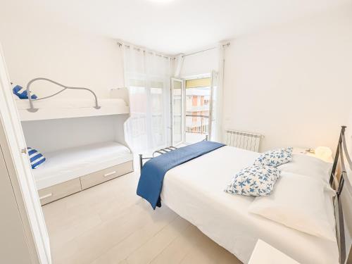 a white bedroom with a bed and a window at DanysHome Giove davanti al mare in Terracina