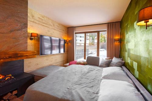 1 dormitorio con cama, TV y chimenea en Apartmán Skalka na Šumavě, Železná Ruda, en Železná Ruda