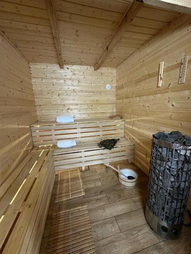 a wooden sauna with a toilet and a trash can at Pałac Sapetów in Tuczno